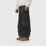 Pantalón de jean estilo ultra baggy, color negro con efecto lavado. Presenta un diseño de corte amplio con costuras reforzadas y detalles de bordes desflecados en los bolsillos laterales tipo cargo.