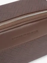 Cartera bandolera Tommy Hilfiger de color marrón, con diseño texturizado, paneles combinados y motivo integral de logos en relieve. Cuenta con cierre de cremallera, compartimento principal y correa ajustable.