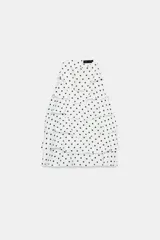 Top halter blanco con estampado de lunares negros y diseño de múltiples volantes en capas.