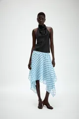 Falda midi de tiro medio color celeste con estampado de lunares negros, diseño asimétrico y forro interior. Cuenta con cierre lateral de cremallera oculta.
