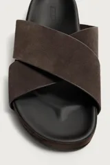 Sandalias de cuero con acabado de gamuza, color marrón, con dos tiras anchas cruzadas en el empeine y suela plana.