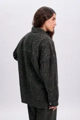 Sobrecamisa de denim con estampa de cebra en color verde militar, de corte oversize, cuello camisero, bolsillos frontales con solapa y cierre de botones metálicos.