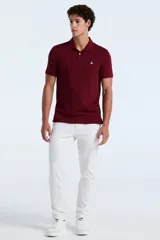 Polo de manga corta en color bordó, confeccionada en tejido piqué de algodón. Presenta cuello clásico, cierre frontal con dos botones y el logo de la marca bordado en el pecho.