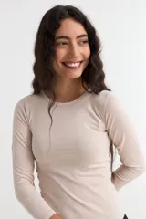 Remera de manga larga con cuello redondo a la base, confeccionada en algodón suave de corte ajustado.