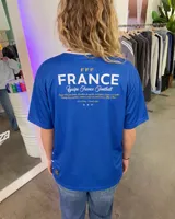 Remera de fútbol inspirada en la selección de Francia, de color azul con franjas horizontales blancas y una franja roja en el pecho, cuello en V blanco y dorsal 10 en la parte frontal.
