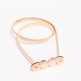 Cinturón elástico dorado, tipo fajín, con cierre frontal compuesto por tres discos metálicos y ganchos ovalados a los extremos.