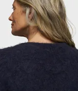 Sweater corto de punto color azul marino, de corte holgado y cuello redondo. Confeccionado en una mezcla de alpaca y lana cepillada con acabado suave y ribetes elásticos.