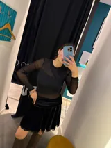 Falda corta de terciopelo negro con cintura elástica y detalle de encaje en el ruedo.