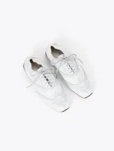 Zapato de cuero vacuno color blanco con acabado arrugado, diseño estilo oxford con detalles perforados, cordones y tacón bajo decorado con pedrería.