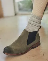 Botín Chelsea de cuero color beige con elástico lateral negro, puntera redondeada y suela plana.