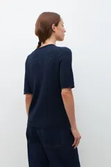 Cardigan gris melange de tejido de punto con diseño texturizado, manga corta y cierre frontal con botones.