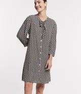 Vestido chemise midi de viscosa con estampado geométrico en blanco y negro. Tiene lazo en el cuello, abotonadura frontal y mangas 3/4.