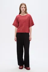Blusa de viscosa color marrón rojizo, con diseño holgado, cuello a la base, mangas cortas y detalle de bordado floral en tono sobre tono.
