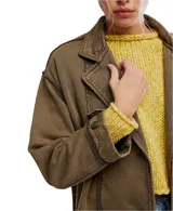 Chaqueta estilo blazer de algodón color marrón oliva, con efecto desgastado y costuras marcadas. Presenta solapas anchas, cierre frontal de dos botones y puños anchos ajustables con botón.