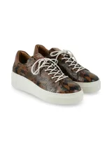 Championes de cuero con estampado animal print de serpiente en tonos marrones y negros, con suela plataforma blanca y cordones blancos.