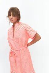 Vestido amarillo neón con textura arrugada, corte recto, largo hasta la rodilla, manga corta y cuello mao con abertura en V.