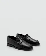 Mocasines de piel vacuna en color negro, de diseño clásico con suela plana y costuras visibles en el empeine.