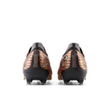 Championes de fútbol New Balance Tekela V4 Pro Low FG, color cobre con detalles en negro y gris.