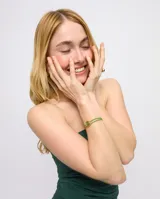 Pulsera de cuero verde con doble tira, dije central dorado con forma de ojo y cristal verde.