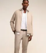 Pantalón de vestir color beige con estampa de cuadros en hilo teñido, corte slim, cintura con trabillas, cierre con botón y cremallera, bolsillos laterales y traseros.