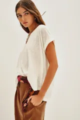 Remera de manga corta color blanco roto, con escote bote y calce holgado.