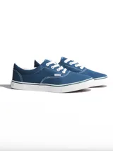 Championes de lona color azul grisáceo, estilo skate o casual, con cordones blancos y suela de goma blanca con una línea fina azul en el borde.