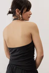 Top negro con diseño cruzado tipo halter, escote pronunciado y fruncido lateral.
