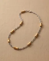 Cadena de acero combinada con eslabones plateados y apliques cilíndricos dorados intercalados.