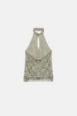 Top halter confeccionado en mezcla de poliamida, color verde militar, con diseño cut-out en el escote, espalda descubierta y aplicaciones de abalorios y lentejuelas brillantes. Presenta bajo recto con flecos colgantes de cuentas y cierre posterior con botones en el cuello.