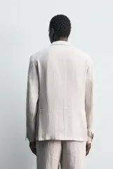 Blazer de corte relajado confeccionado en tejido de lino italiano. Presenta cuello con solapas de muesca, cierre frontal de botones, bolsillos de vivo en el pecho y bolsillos con solapa en la cadera. Cuenta con medio forro interior y aberturas en la parte posterior.