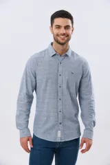 Camisa de manga larga confeccionada en mezcla de lino y algodón, con sutiles rayas celestes, cuello camisero clásico y cierre frontal de botones.