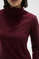 Polera de manga larga con cuello alto, confeccionada en tejido de punto suave.