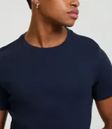 Remera de corte muscle, manga corta y cuello redondo, confeccionada en tejido de media malla. Diseño liso sin estampados.