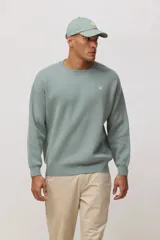 Sweater de punto de cuello redondo y manga larga, con diseño minimalista y logo pequeño bordado en el pecho.