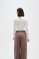 Body de manga larga con cuello alto, confeccionado en tejido al cuerpo.