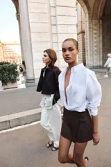 Falda pantalón cruzada de color marrón oscuro, con diseño tipo cargo que incluye bolsillos laterales con solapa y botones decorativos en la cintura.