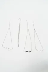 Set de cuatro pulseras de cadena fina en color plateado con diferentes diseños: una con dijes de corazones, una con un dije de corazón grande, una con dijes circulares pequeños y una con eslabones en forma de corazón.