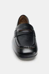 Mocasín de cuero negro con diseño clásico, copete subido, detalle de antifaz en el empeine y terminación en punta cuadrada.