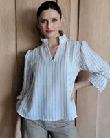 Blusa de algodón con cuello mao y volados, mangas largas con puños elásticos y corte holgado.