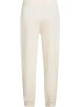 Jogger de corte regular color beige, con cintura elástica con cordón ajustable y puños elásticos en los tobillos. Presenta un pequeño logo bordado en la parte superior.