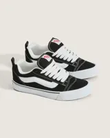 Championes Vans modelo Knu Skool, de diseño inspirado en los años 90 con silueta voluminosa. Confeccionados en gamuza negra, presentan lengüeta y cuello acolchados, Sidestripe en relieve 3D, tiradores en el talón y suela de goma con diseño waffle.