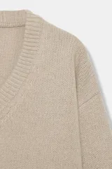 Jersey de punto confeccionado en lana 100%, con escote en pico y manga larga de corte holgado.