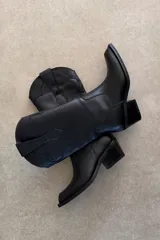 Bota texana de cuero vacuno color bordó con costuras decorativas contrastantes en la caña y taco cuadrado de madera.