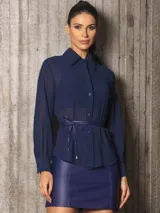 Camisa azul con cuello clásico, mangas largas abullonadas y lazo en la cintura.