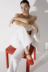 Zapato plano estilo Mary Jane de cuero negro, con punta fina y tira ajustable con hebilla sobre el empeine.