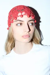 Gorro tipo casquete rojo de crochet con detalle de cuentas rojas alrededor.