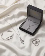 Collar de acero con cadena fina y dije en forma de serpiente, completamente cubierto de circonias blancas y con una circonia verde en el ojo.