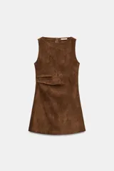 Vestido corto de cuello barco y manga sisa, confeccionado en tejido efecto ante. Presenta un diseño en línea evasé con detalle de pliegues laterales y cierre de cremallera oculta en la espalda.