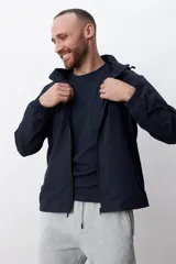 Campera negra con capucha y cierre frontal.