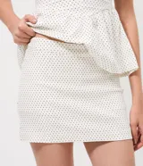 Mini short pollera de bengalina con estampado de lunares, diseño ajustado con cintura estructurada.